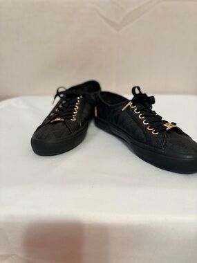 Michael Kors Boerum sneakers featuring a black logo print and gold hardware.